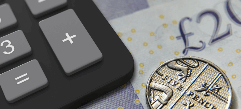 A calculator, a five pence coin, and part of a twenty-pound note