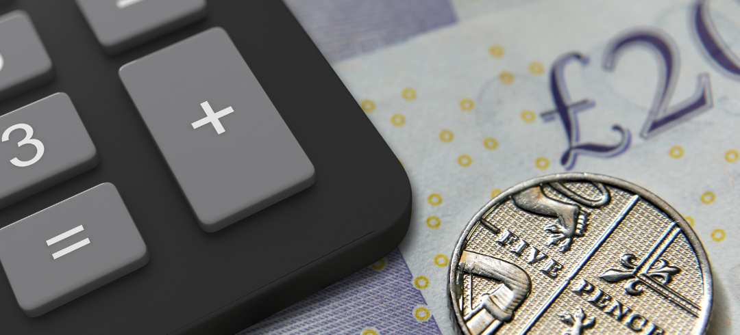 A calculator, a five pence coin, and part of a twenty-pound note