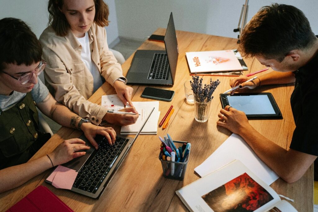 Three people using unified communications tools to collaborate on a creative project