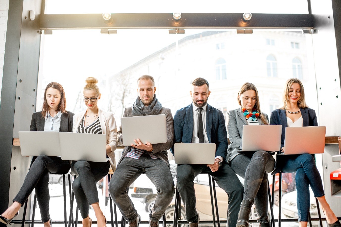 UK office team comparing 5G vs leased line for business connectivity on laptops and phones